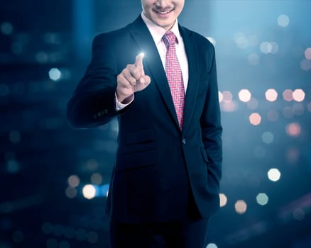 Businessman touching a touch screen on blurred city background