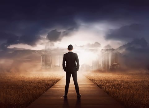 Young asian businessman walking to modern city on the meadow