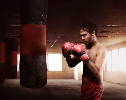 Young asian boxer man with red glove is training and hitting punching bag