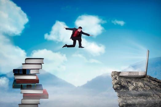 Concept of technology migration with business person jumping from book to laptop