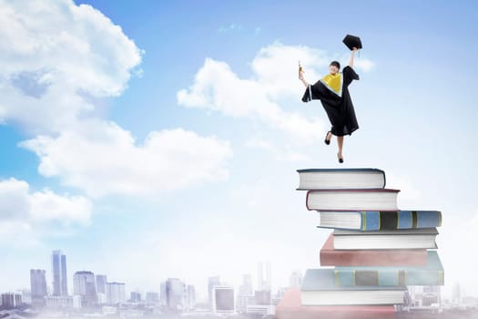 Asian woman student, graduation from college, jumping on the stack of book
