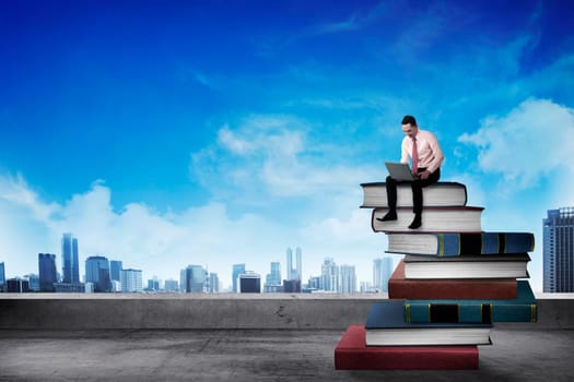 Business person working with laptop on the top of books. Career and education concept