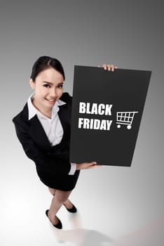 Asian woman in top view perspective holding banner with black friday writing