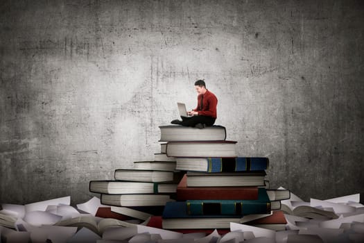 Asian business person working with laptop sit on top of book. Idea and knowledge concept