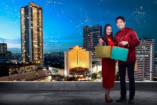 Chinese couple wear cheongsam holding shopping bag on the city