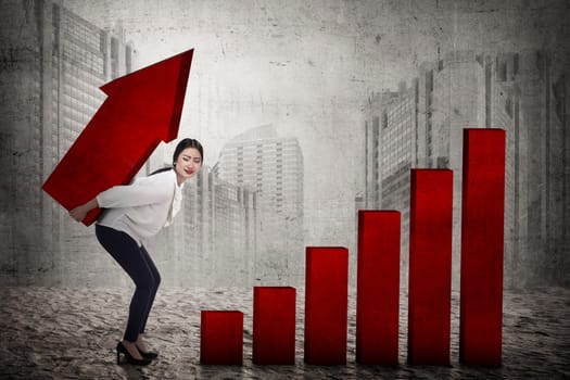 Asian business woman lifting heavy arrow. Business challenge concept