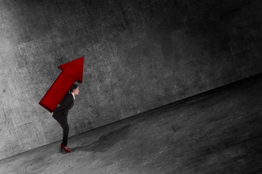 Asian business woman carry big red arrow on her back. Business difficulty concept