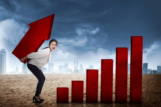 Asian business woman lifting heavy arrow. Business challenge concept