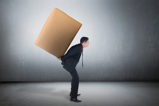 Image of asian business man carrying brown package on his back