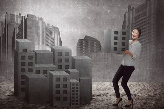 Asian business woman lifting block of city. Building city concept