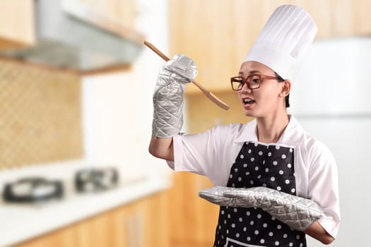 Portrait of young woman chef over kitchen background