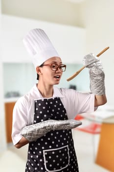 Portrait of young woman chef over kitchen background