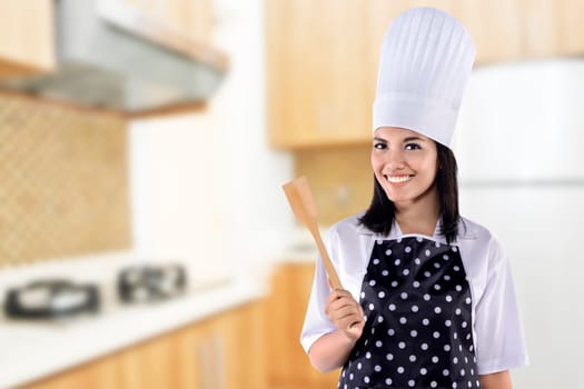Portrait of young woman chef over kitchen background