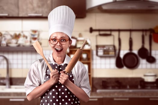 Portrait of young woman chef over kitchen background