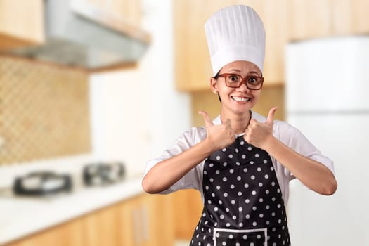 Portrait of young woman chef over kitchen background