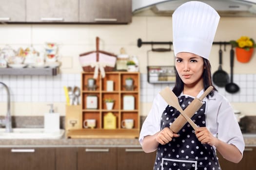Portrait of young woman chef over kitchen background