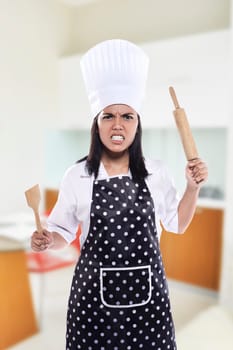 Portrait of young woman chef over kitchen background
