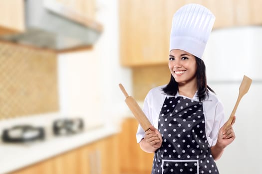 Portrait of young woman chef over kitchen background