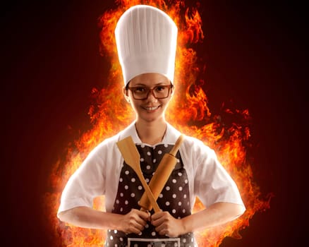 Portrait of young woman chef with fire around her