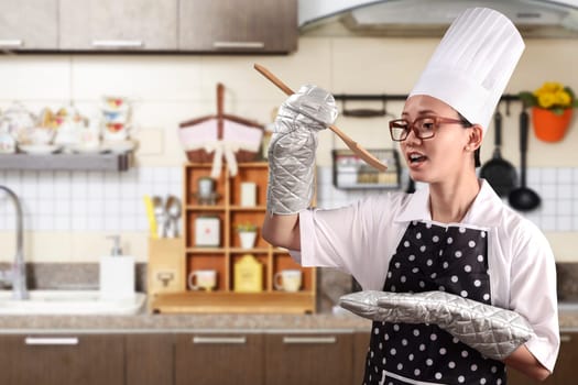 Portrait of young woman chef over kitchen background