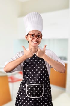 Portrait of young woman chef over kitchen background