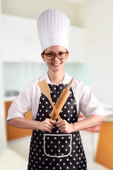 Portrait of young woman chef over kitchen background