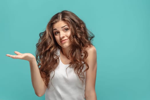 The portrait of alarmed young woman with shocked facial expression Presenting something