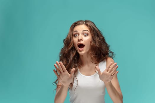 The portrait of alarmed young woman with shocked facial expression