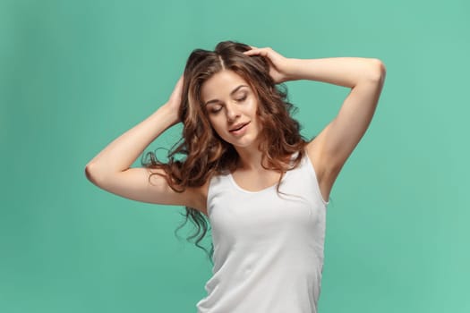 The young woman's portrait with happy emotions on blue background