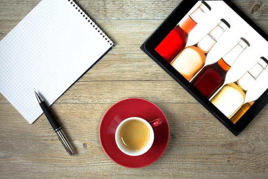 Tablet with bottles of lemonade and block for shopping as a top view on the table