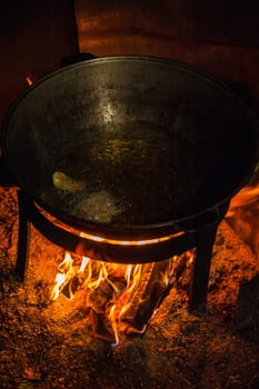 Camping fire and kettle with frying fish