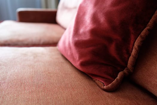 Cushion red on sofa with armrest as upholstered furniture in backlight