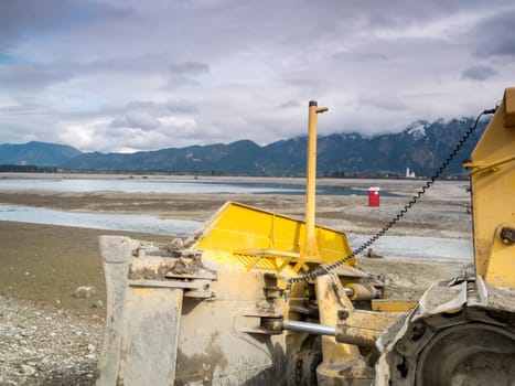 Bulldozer in the drained Forggensee near Füssen / Bavaria. The Forggensee is fed by thawing snow from the high Alps and is a reservoir for sedimentary rocks. In spring,the lake is emptied to remove the sedimentary rock. In summer,the lake has returned to its normal water level and is navigated by excursion boats.