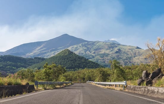 Road on the south side of Mount Etna, with central crater on background