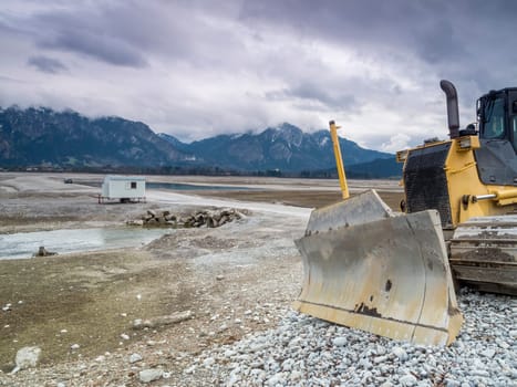 Shield of a bulldozer in the drained Forggensee near Füssen / Bavaria. The Forggensee is fed by thawing snow from the high Alps and is a reservoir for sedimentary rocks. In spring,the lake is emptied to remove the sedimentary rock. In summer,the lake has returned to its normal water level and is navigated by excursion boats.
