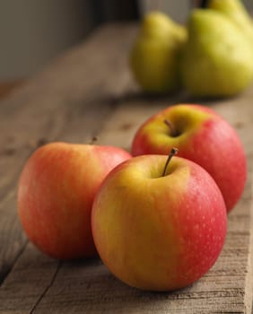 Red apples and gree pears on a rustic wooden table