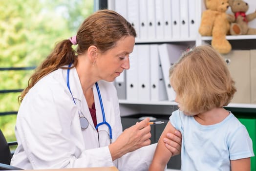 female pediatrician in white lab coat injected a medicament
