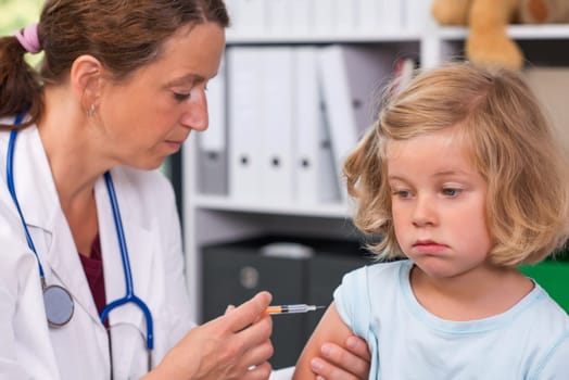 female pediatrician in white lab coat injected a medicament
