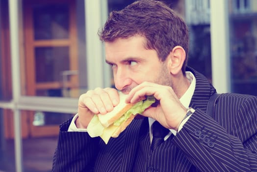 businessman in suit in front of city- background is eating