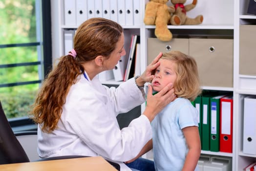 female pediatrician in white lab coat examined little girl