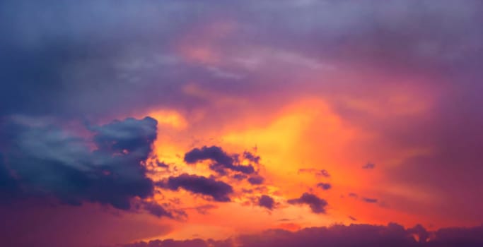 Sunset amid thunderclouds. Sunset shines red through dark clouds.