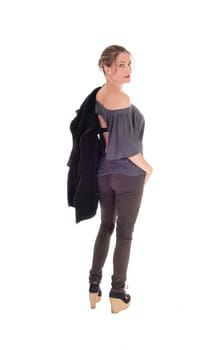 A slim young woman in jeans with her jacket over her shoulder is.ready for a walk, isolated for white background..
