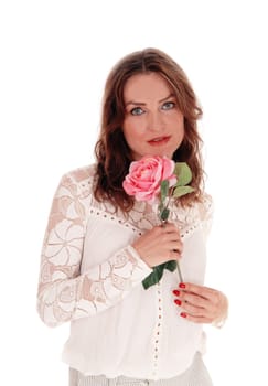 A beautiful young Caucasian woman in a lace blouse and brunette hair.holding a pink rose in her hand, isolated for white background..