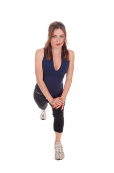 A beautiful woman in exercising outfits stretching her legs after some.exercising, isolated for white background..