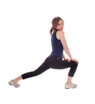 A slim young woman stretching her legs after some exercising, wearing.sportswear, isolated for white background..
