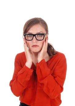 A young afraid looking woman with her hands on her face wearing.black glasses standing isolated for white background..