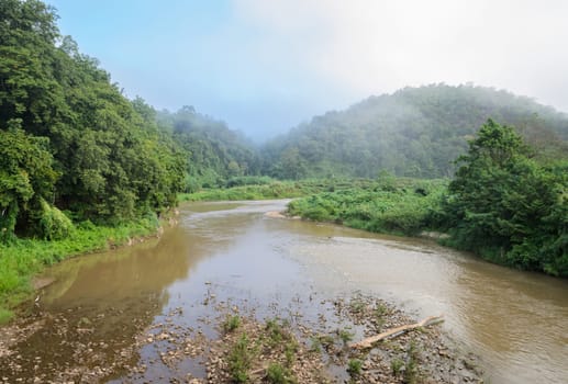 Morning mist on a calm river in rainforest mountain, Thailand