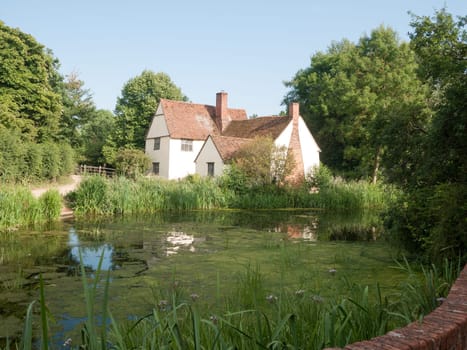 Side view of Willy Lotts' cottage and river front on a clear sunny day  Suffolk  UK