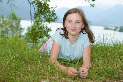 a beautiful pre teenage girl laying in grass