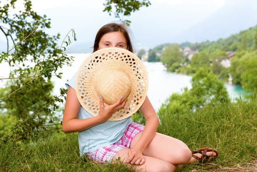 a teenager girl with a straw hat in the wild